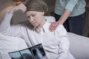 Broken down young cancer woman sitting at home with friend